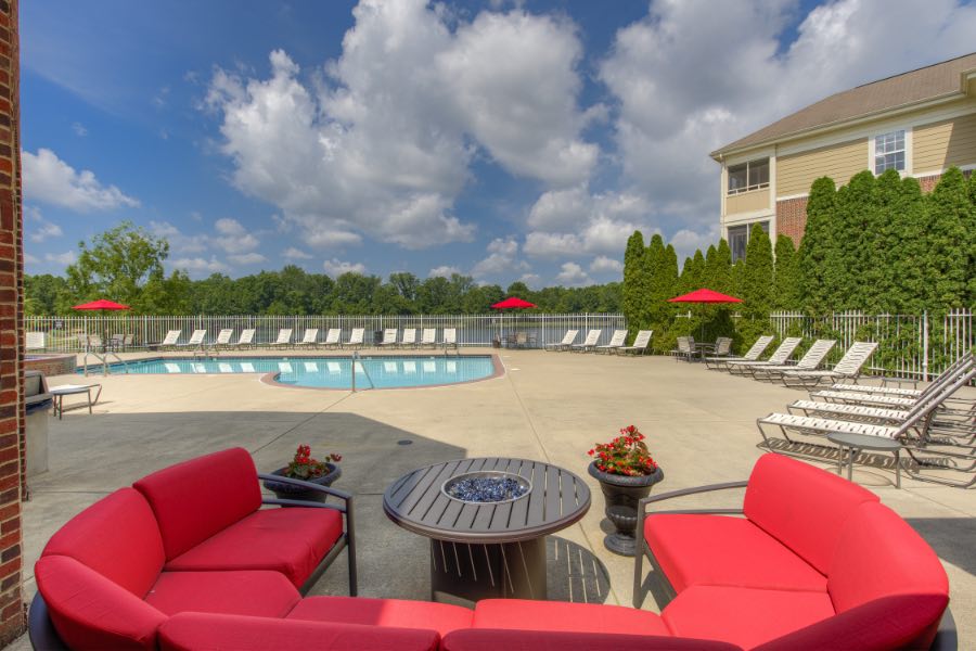 Apartment swimming pool area with cushioned red seating